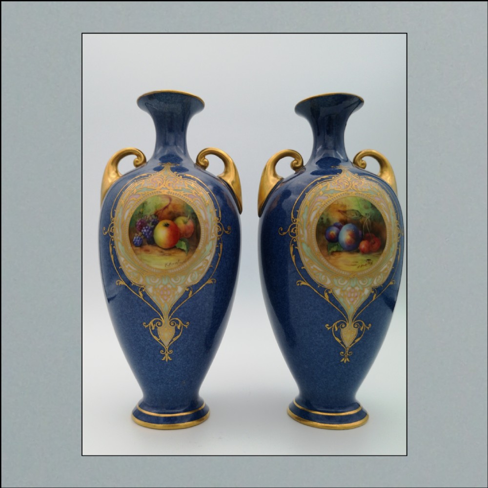 A Pair of rare Royal Worcester  Powder Blue 1923 both signed H.Ayrton decorated with vignettes of fruit.