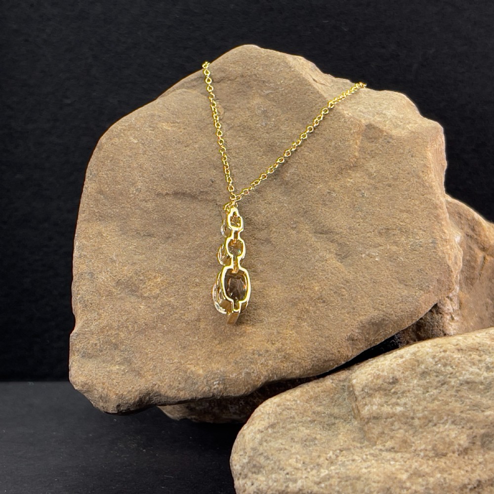 A 9ct yellow gold drop pendant featuring three graduated cushion-cut gemstones on a fine link chain. View IV