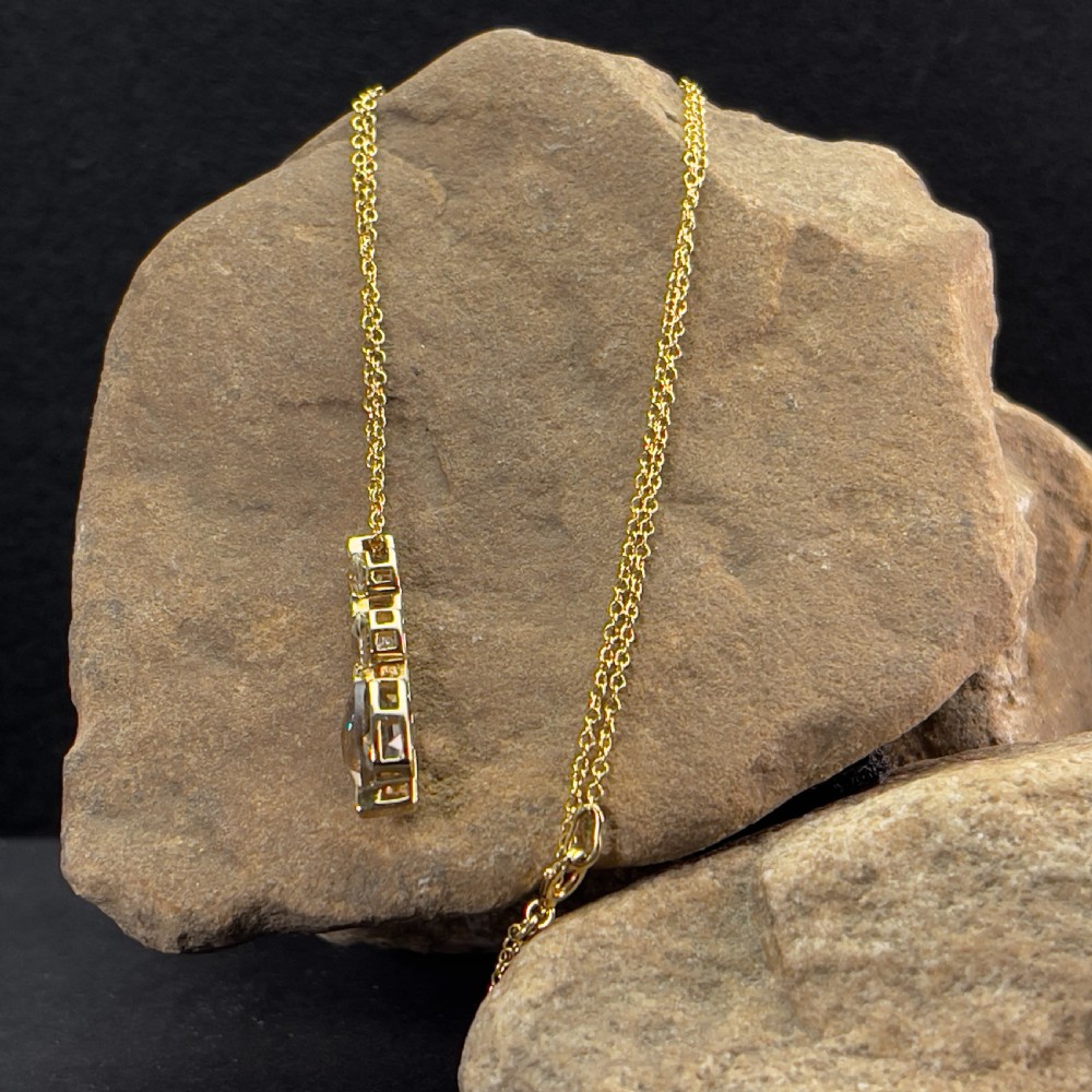 A 9ct yellow gold drop pendant featuring three graduated cushion-cut gemstones on a fine link chain. View VI
