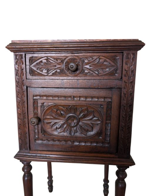 fig 1. Carved dark oak bedside cabinet featuring a single drawer, cupboard door, marble insert top, and slender turned legs.