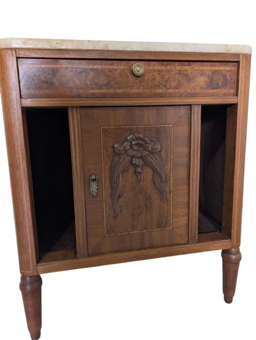 fig 1. An antique walnut bedside cabinet featuring a beige marble top, a single upper drawer with a brass knob, turned legs, and a central carved door.