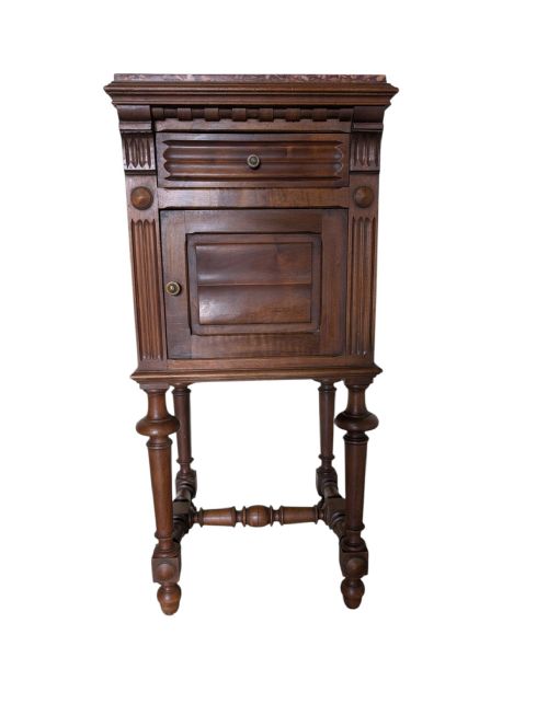 fig 1. A tall dark walnut antique bedside cabinet featuring a marble top, a top drawer, a panelled cupboard door, fluted pilasters, turned legs, and an H-stretcher.