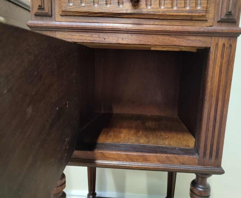 A pair of dark wood French bedside cabinets featuring carved drawer fronts, single cupboards, turned fluted legs, and variegated marble tops. View IX