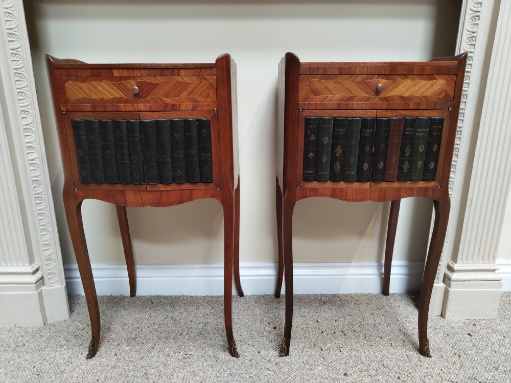 A pair of antique French-style inlaid wooden bedside cabinets featuring parquetry tops, curved cabriole legs with brass feet, and faux book spine doors. View II