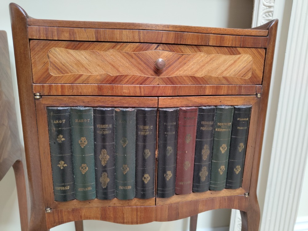 A pair of antique French-style inlaid wooden bedside cabinets featuring parquetry tops, curved cabriole legs with brass feet, and faux book spine doors. View III