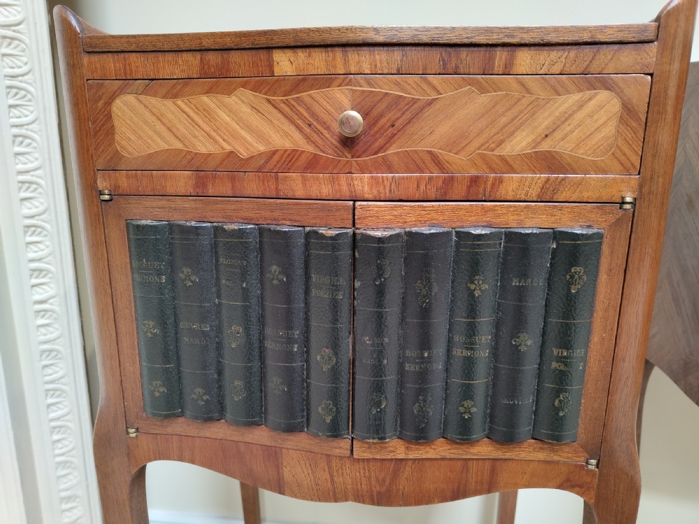 A pair of antique French-style inlaid wooden bedside cabinets featuring parquetry tops, curved cabriole legs with brass feet, and faux book spine doors. View IV