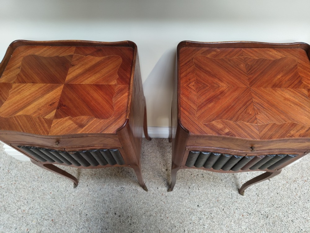 A pair of antique French-style inlaid wooden bedside cabinets featuring parquetry tops, curved cabriole legs with brass feet, and faux book spine doors. View VII