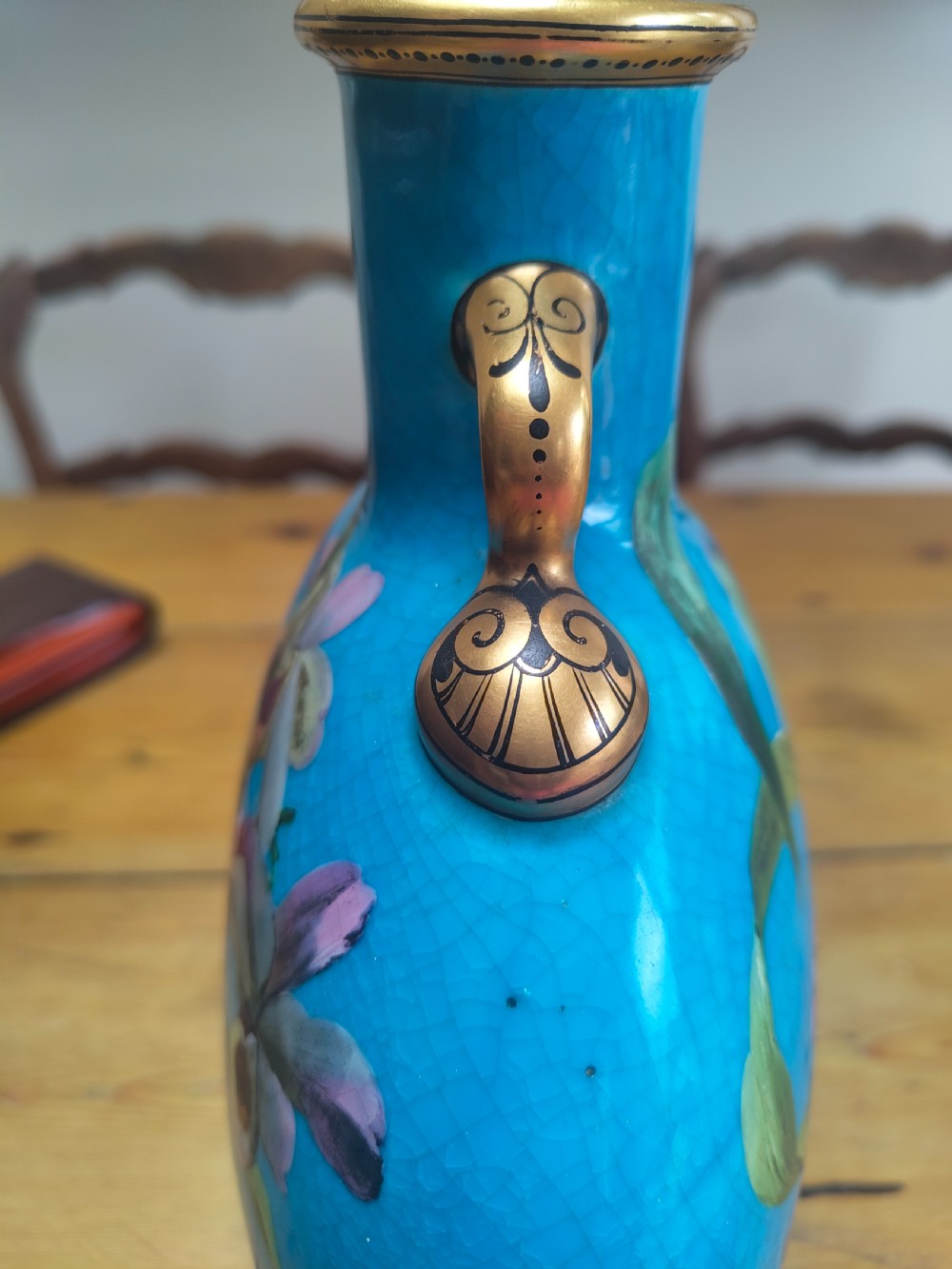 A turquoise porcelain vase featuring twin gilded handles, decorated with hand-painted orchid flowers and a crackle glaze finish. View VII