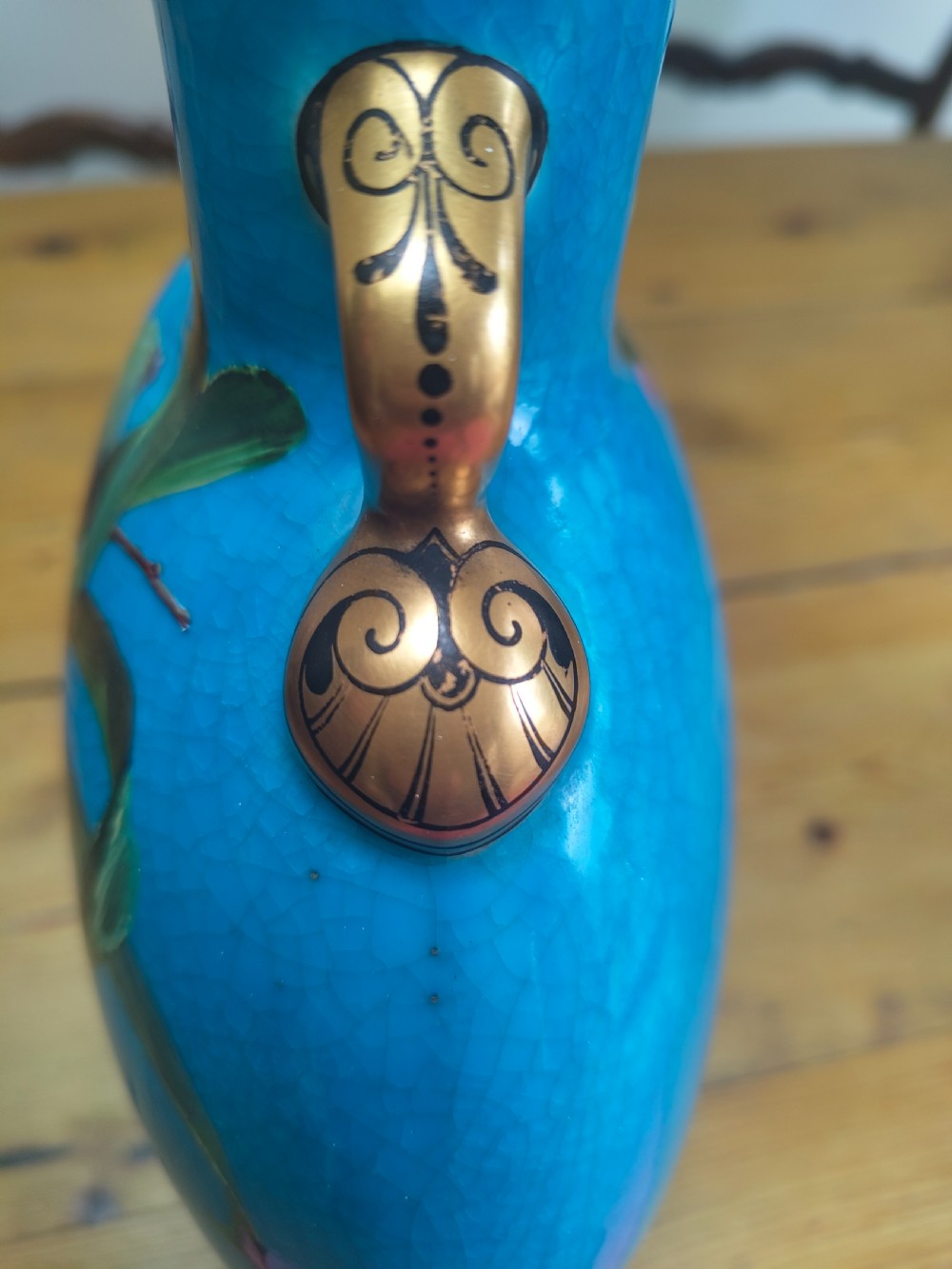 A turquoise porcelain vase featuring twin gilded handles, decorated with hand-painted orchid flowers and a crackle glaze finish. View IX