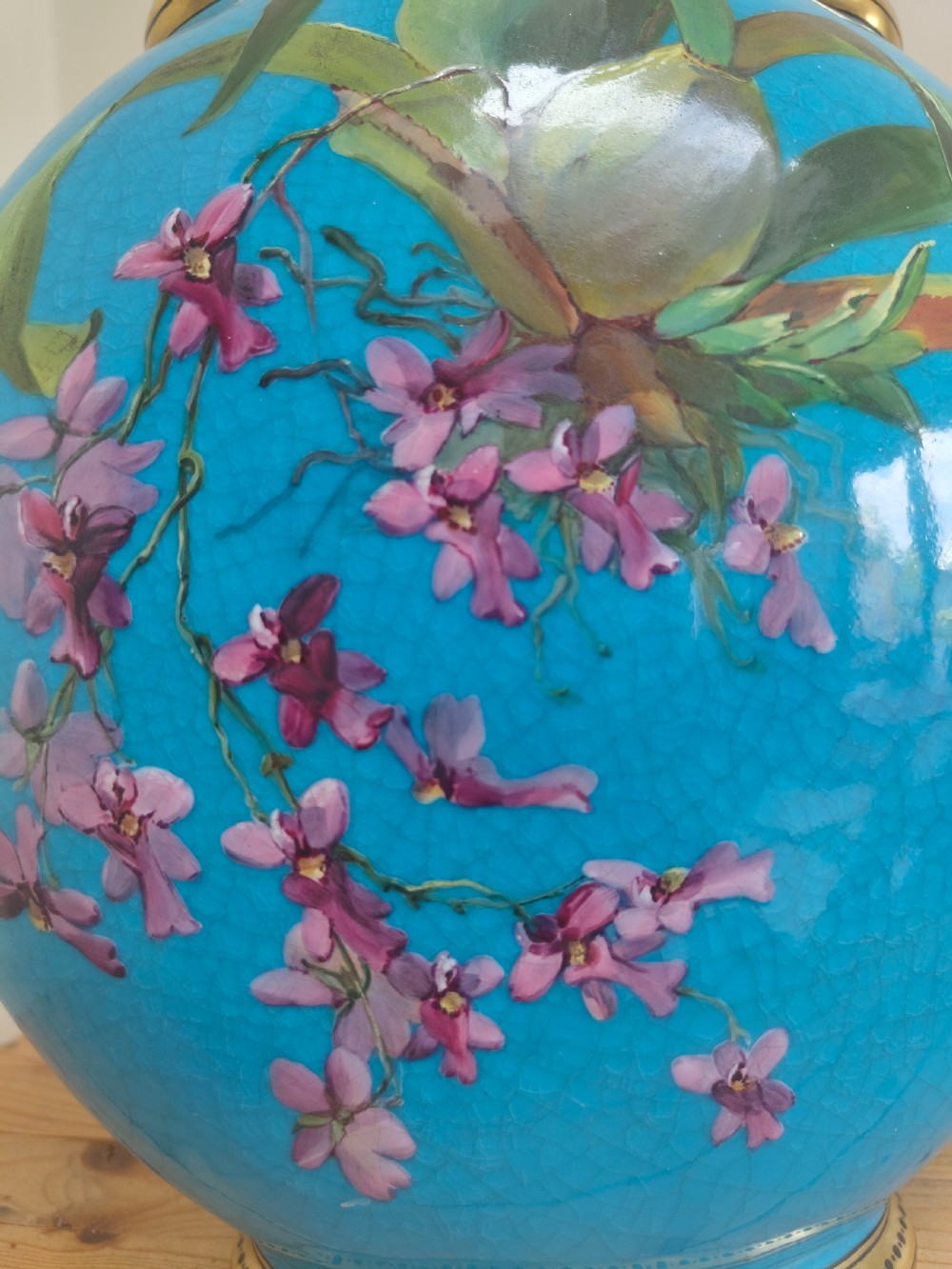 A turquoise porcelain vase featuring twin gilded handles, decorated with hand-painted orchid flowers and a crackle glaze finish. View XI