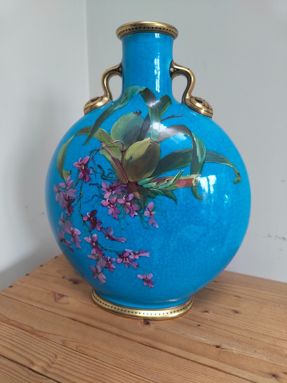 A turquoise porcelain vase featuring twin gilded handles, decorated with hand-painted orchid flowers and a crackle glaze finish. View XII