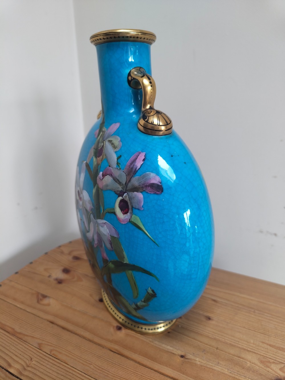 A turquoise porcelain vase featuring twin gilded handles, decorated with hand-painted orchid flowers and a crackle glaze finish. View XIII
