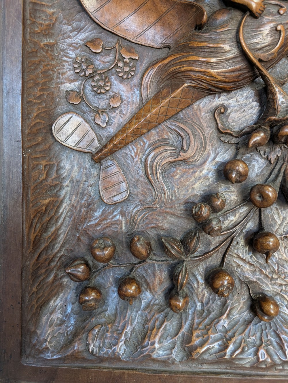 An arched carved wood wall panel featuring high-relief details of figures on a flying vessel, an eagle, a sun, and botanical elements in a warm brown finish. View IV
