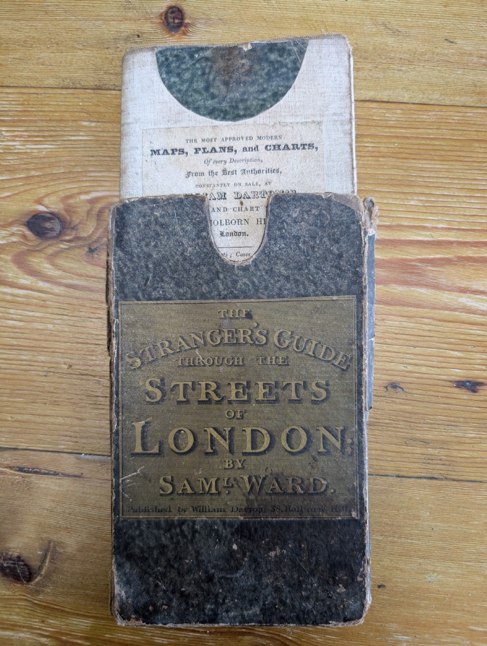 An antique printed paper pocket map of London in a dark slipcase titled The Strangers Guide Through the Streets of London by Saml. Ward.
