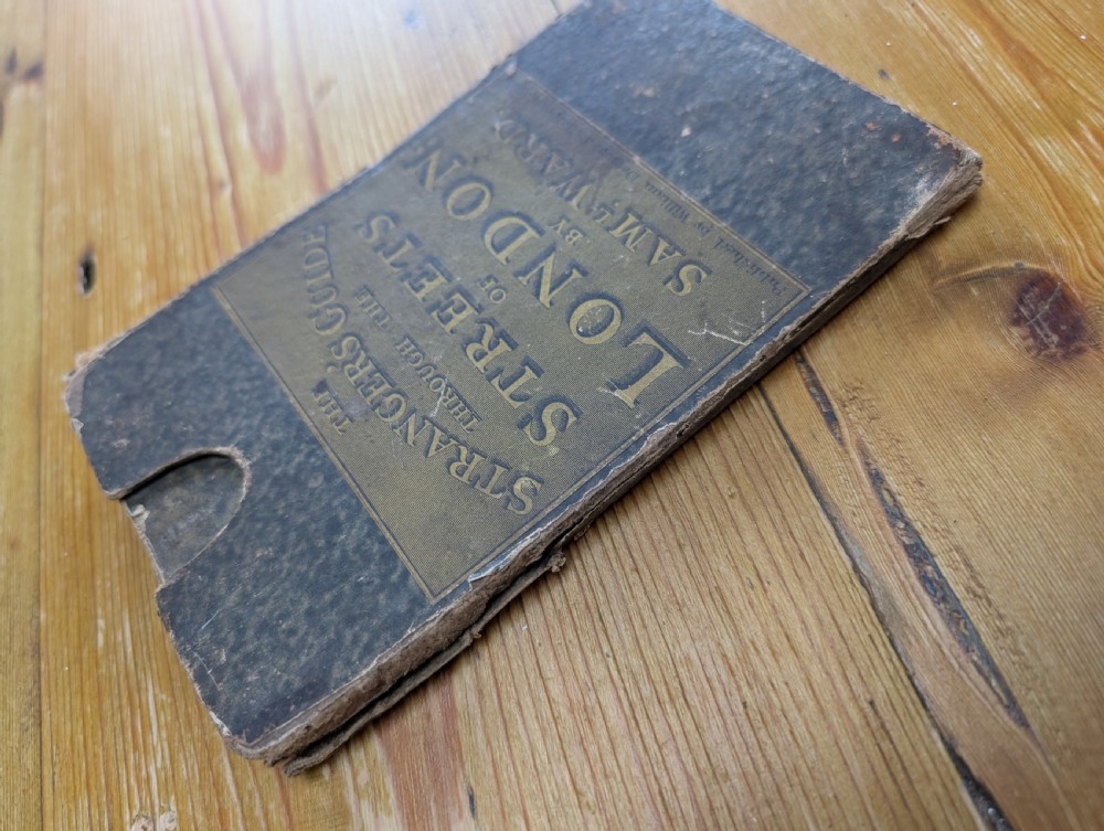 An antique printed paper pocket map of London in a dark slipcase titled The Strangers Guide Through the Streets of London by Saml. Ward. View II