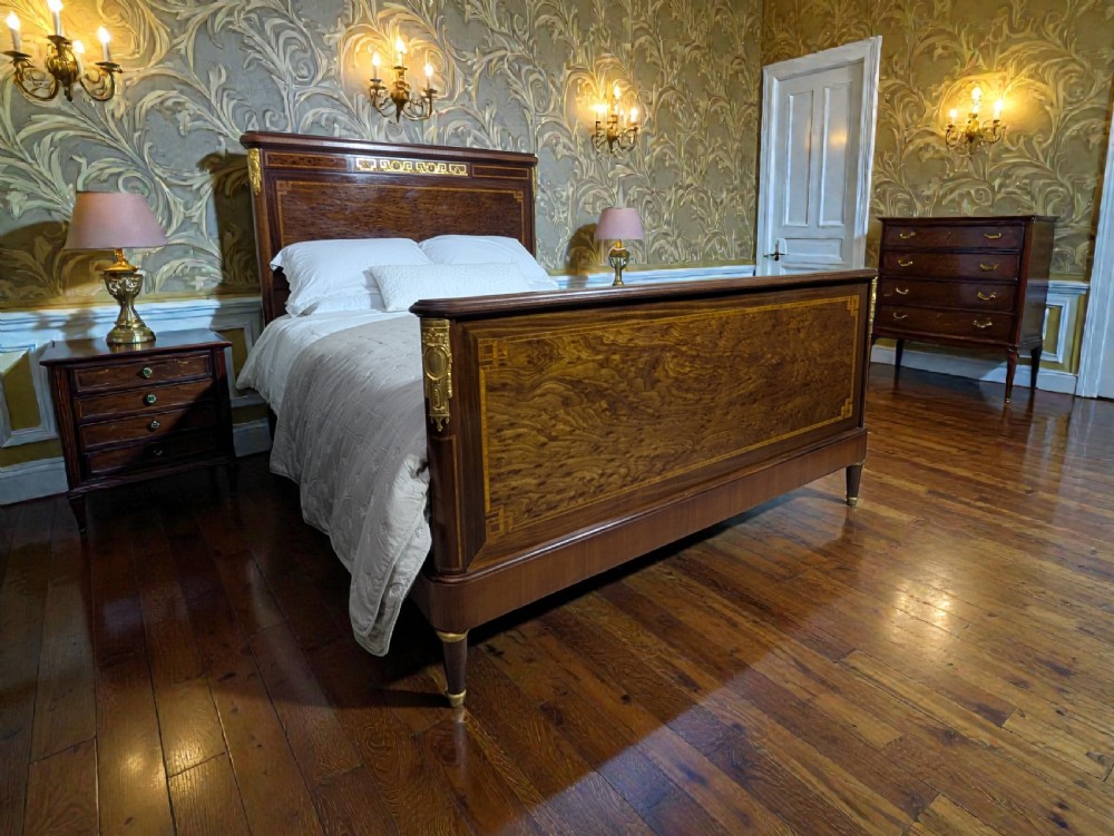 An antique king-sized wooden bed frame featuring rich burr walnut panels, crossbanded inlay, and decorative gilt bronze mounts on the headboard and footboard. View II