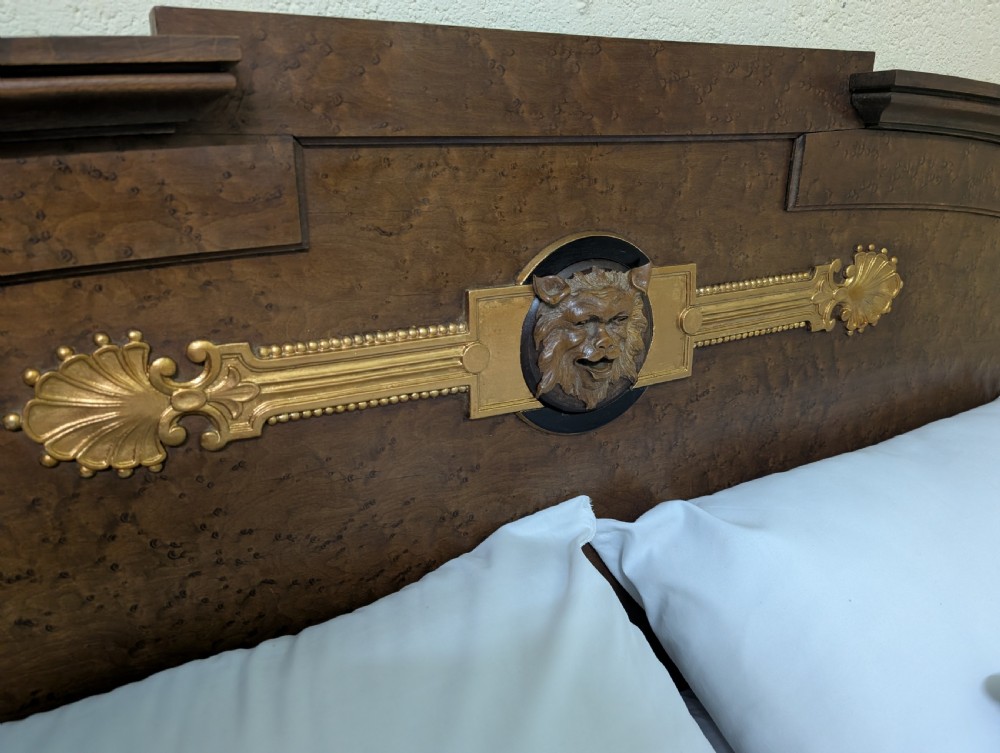 An Empire style king-sized bedstead crafted in golden veneered wood with gilt mounts and a Greek key border along the footboard base. View X