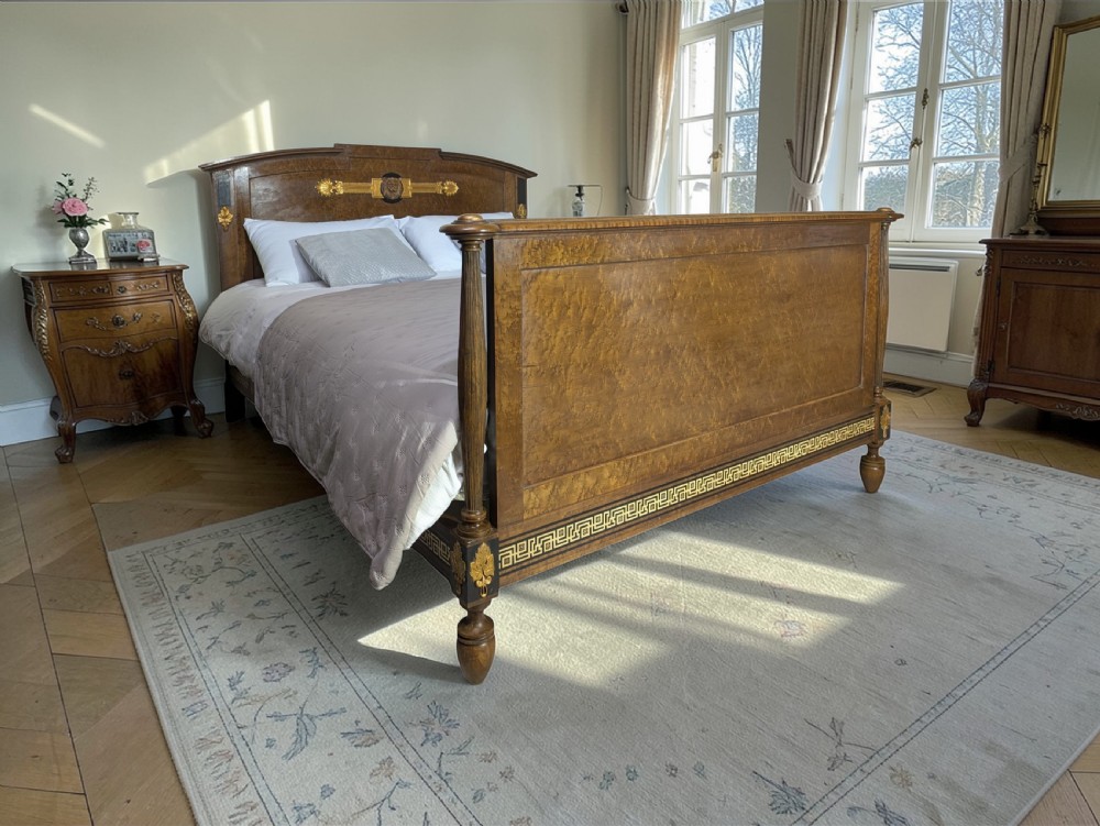 An Empire style king-sized bedstead crafted in golden veneered wood with gilt mounts and a Greek key border along the footboard base. View XVIII