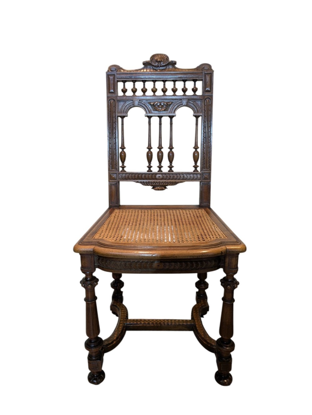 A set of four antique dark carved oak dining chairs featuring openwork spindle backs and woven cane seats. View II