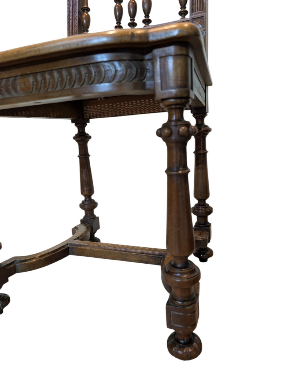 A set of four antique dark carved oak dining chairs featuring openwork spindle backs and woven cane seats. View III