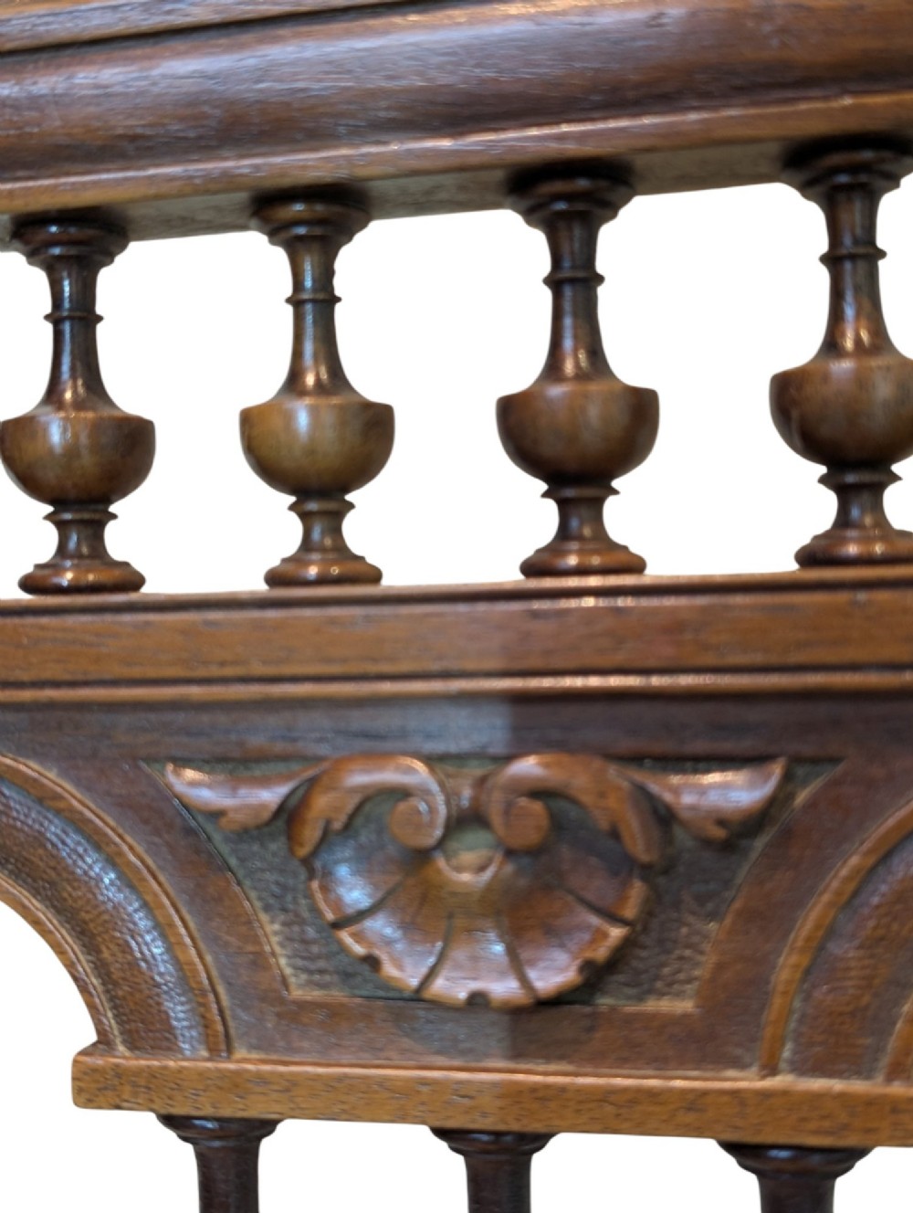 A set of four antique dark carved oak dining chairs featuring openwork spindle backs and woven cane seats. View VII