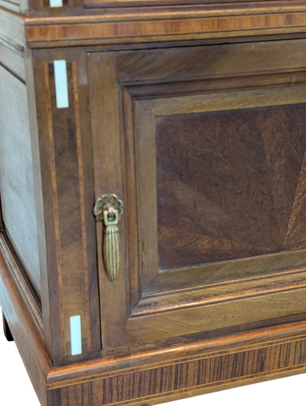 An antique dark wood bedside cabinet featuring an open upper compartment, a lower single door cupboard with marquetry detail, white line inlays, and short curved legs. View IV
