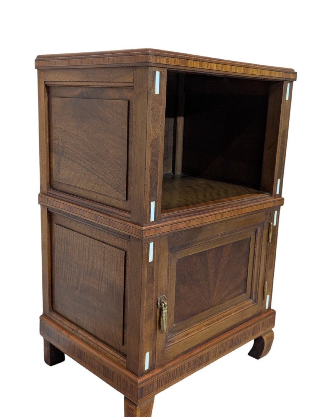 An antique dark wood bedside cabinet featuring an open upper compartment, a lower single door cupboard with marquetry detail, white line inlays, and short curved legs. View V