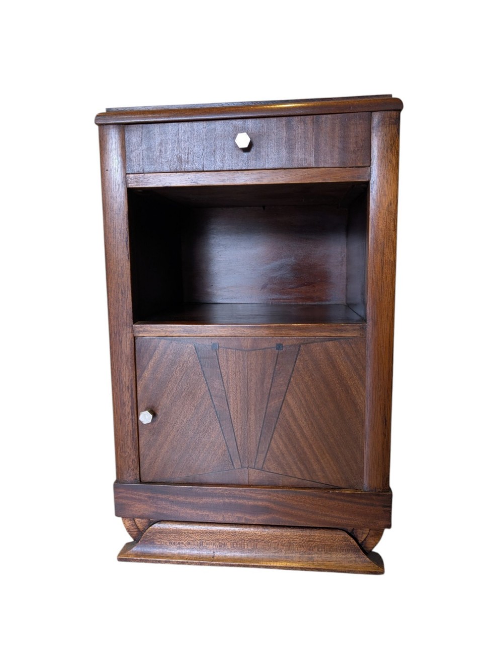 A dark brown walnut Art Deco bedside cabinet featuring a top drawer, an open central shelf, a cupboard door with geometric veneer inlay, and hexagonal metal knobs. View II