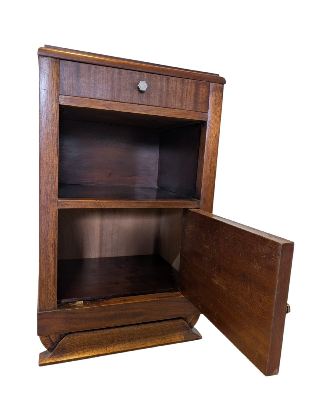 A dark brown walnut Art Deco bedside cabinet featuring a top drawer, an open central shelf, a cupboard door with geometric veneer inlay, and hexagonal metal knobs. View V