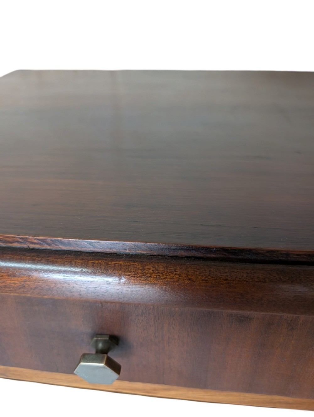 A dark brown walnut Art Deco bedside cabinet featuring a top drawer, an open central shelf, a cupboard door with geometric veneer inlay, and hexagonal metal knobs. View X