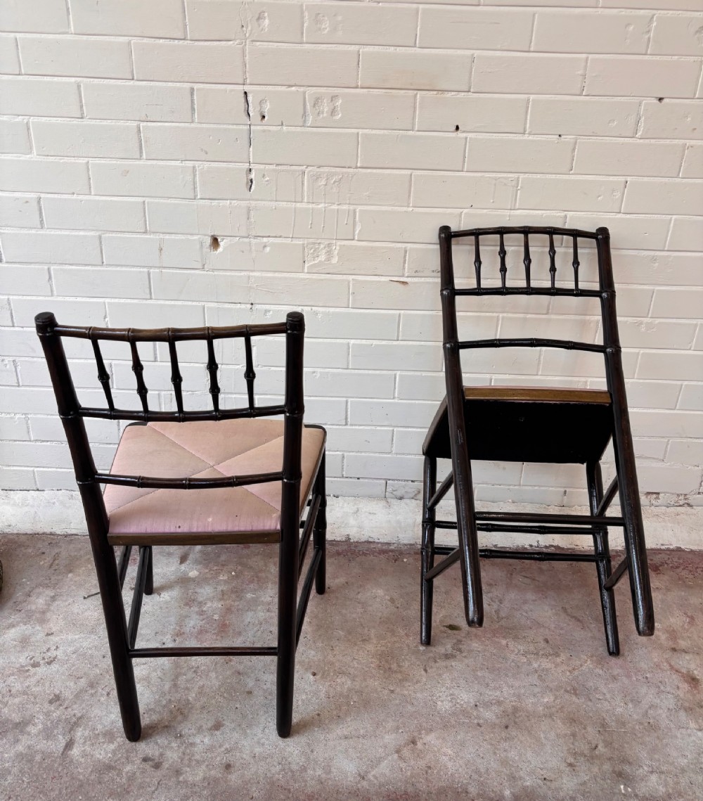 A pair of dark wood side chairs featuring turned frames imitating bamboo and light beige woven rush envelope seats. View III