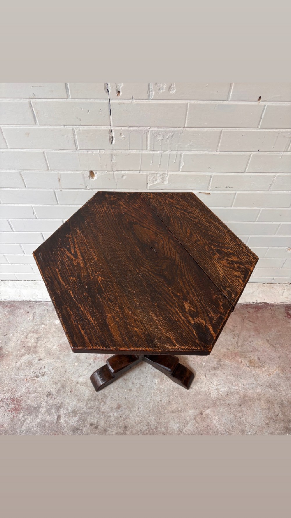 A dark oak pedestal side table featuring a hexagonal top resting on a carved central stem with tripod legs. View III