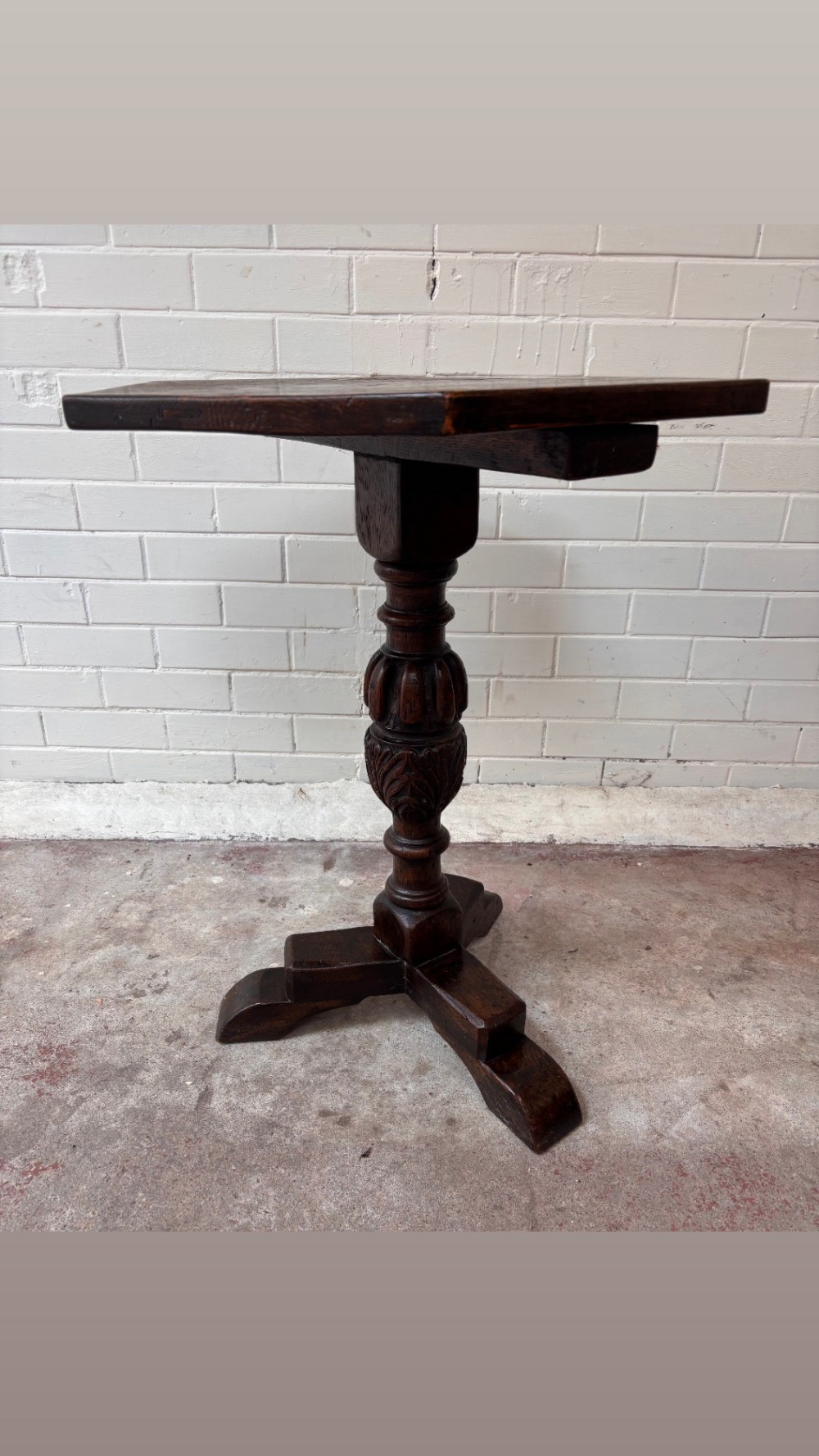 A dark oak pedestal side table featuring a hexagonal top resting on a carved central stem with tripod legs. View V
