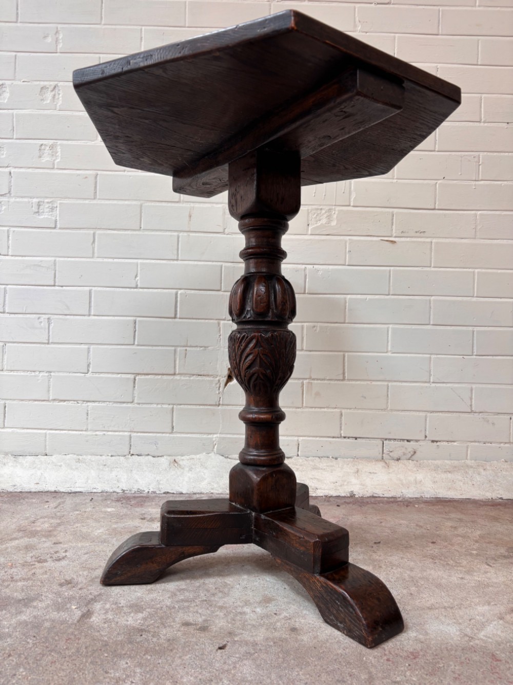 A dark oak pedestal side table featuring a hexagonal top resting on a carved central stem with tripod legs. View VI