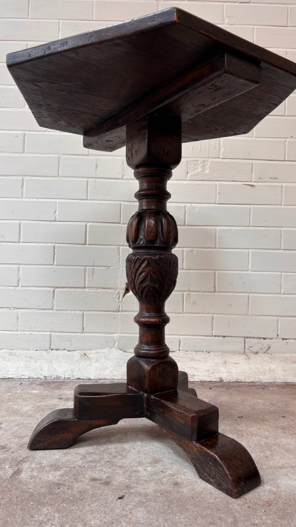 A dark oak pedestal side table featuring a hexagonal top resting on a carved central stem with tripod legs. View VII
