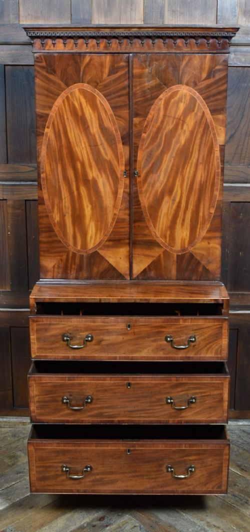 A tall Georgian mahogany secretaire bookcase featuring an upper two-door cabinet with oval inlay panels above a lower chest with four drawers and brass swan-neck handles. View IV