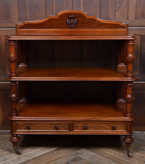 fig 1. A Victorian mahogany three-tiered whatnot featuring turned column supports, two lower drawers with knob handles, an arched gallery top, and brass castors.