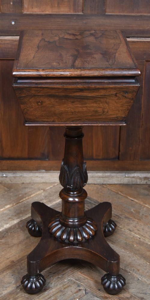 A Victorian dark rosewood teapoy featuring a sarcophagus-shaped chest top resting on a turned carved pedestal and quadruped base. View IX