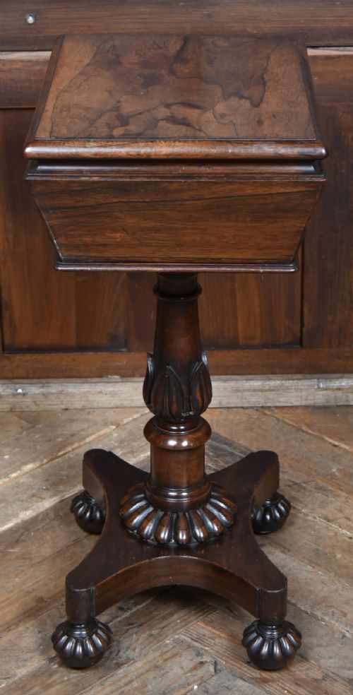A Victorian dark rosewood teapoy featuring a sarcophagus-shaped chest top resting on a turned carved pedestal and quadruped base. View XI