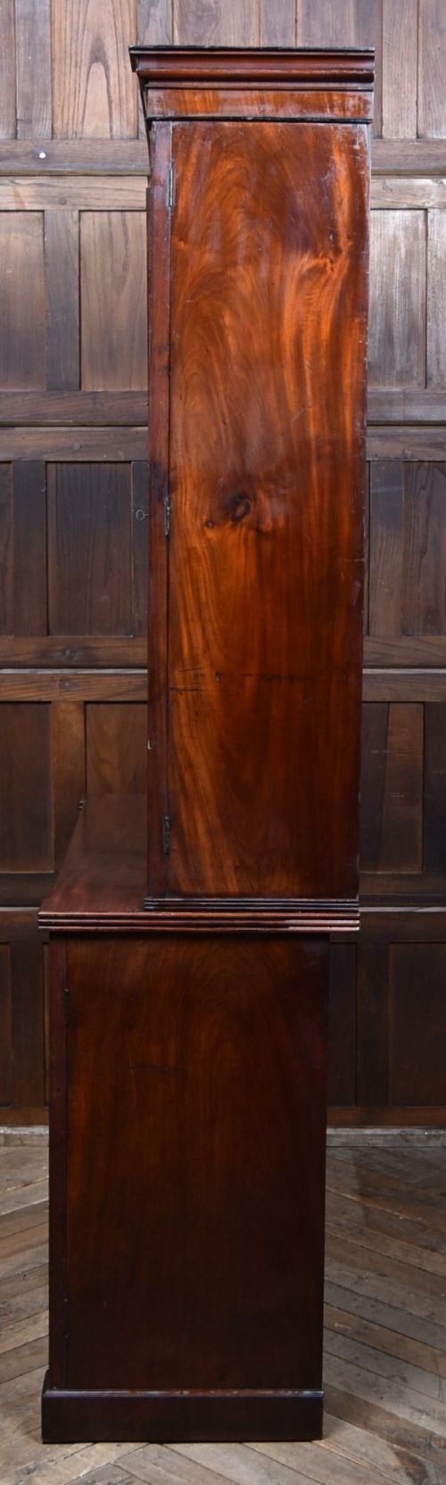 An antique two-part Georgian mahogany bookcase featuring double upper doors with diamond brass wire grilles over lower flame mahogany cupboard doors. View XII