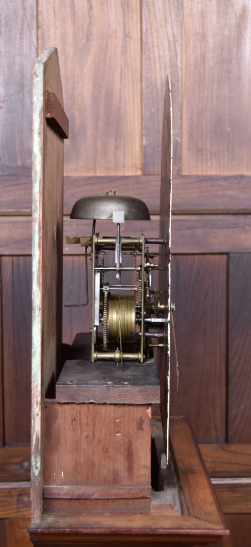 An antique Scottish flame mahogany longcase clock featuring a swan-neck pediment with brass finials and an arched painted dial. View XIV