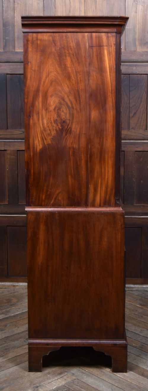 A tall Georgian mahogany chest on chest featuring two stacked tiers of drawers with brass swan-neck handles resting on bracket feet. View X