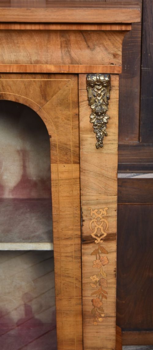 A Victorian walnut pier cabinet featuring double glazed arched doors, floral marquetry inlay, and decorative ormolu mounts. View VIII