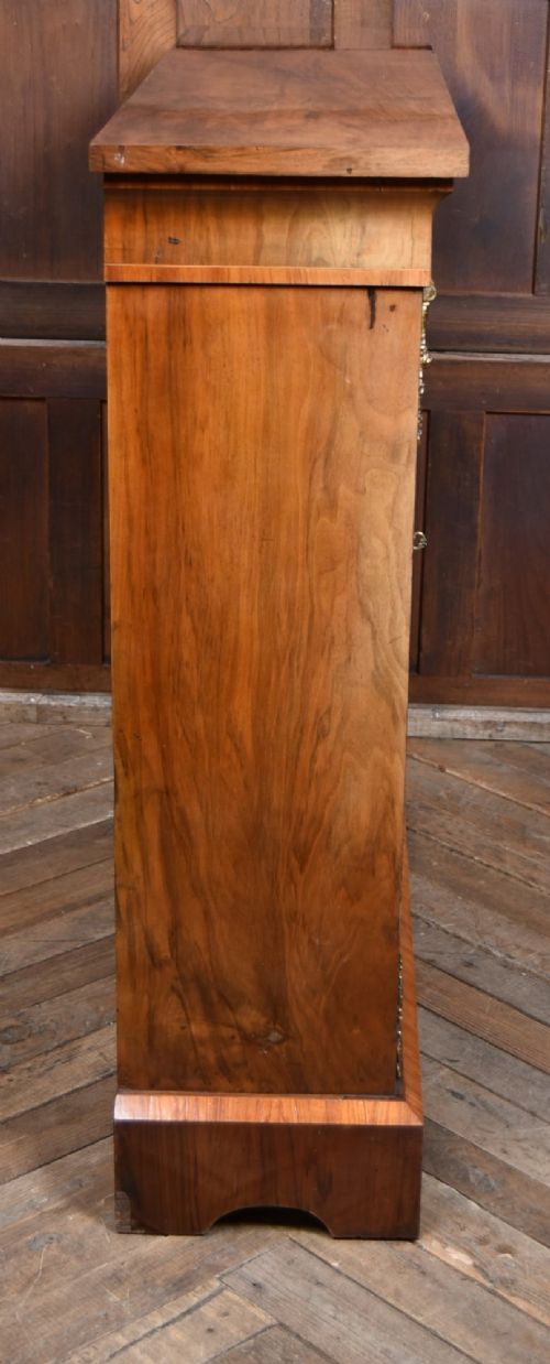 A Victorian walnut pier cabinet featuring double glazed arched doors, floral marquetry inlay, and decorative ormolu mounts. View X