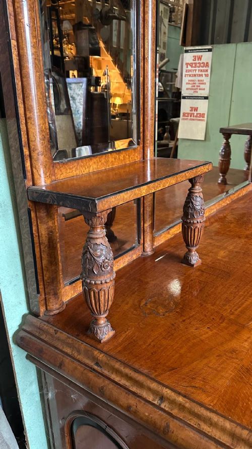 A large Victorian pollard oak mirror-back sideboard featuring carved urn finials, central mirror glass, open side shelving, and ebonised drawer borders. View V