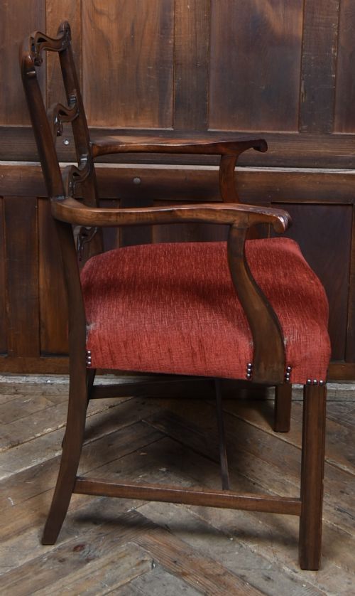 A set of Chippendale Revival mahogany dining chairs featuring carved ladder-back splats and red upholstered seats. View VIII