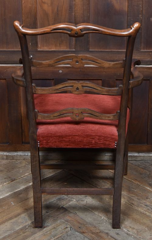 A set of Chippendale Revival mahogany dining chairs featuring carved ladder-back splats and red upholstered seats. View IX