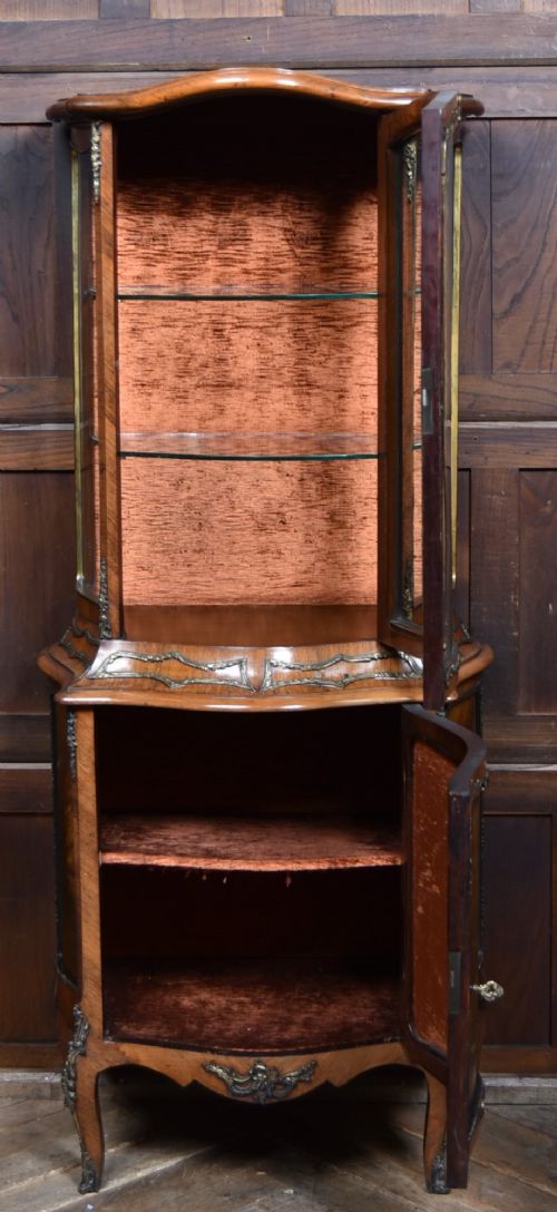 A French walnut vitrine cabinet featuring curved glass upper panels, gilt-bronze ormolu mounts, cabriole legs, and a hand-painted lower door panel depicting a figurative scene. View VIII
