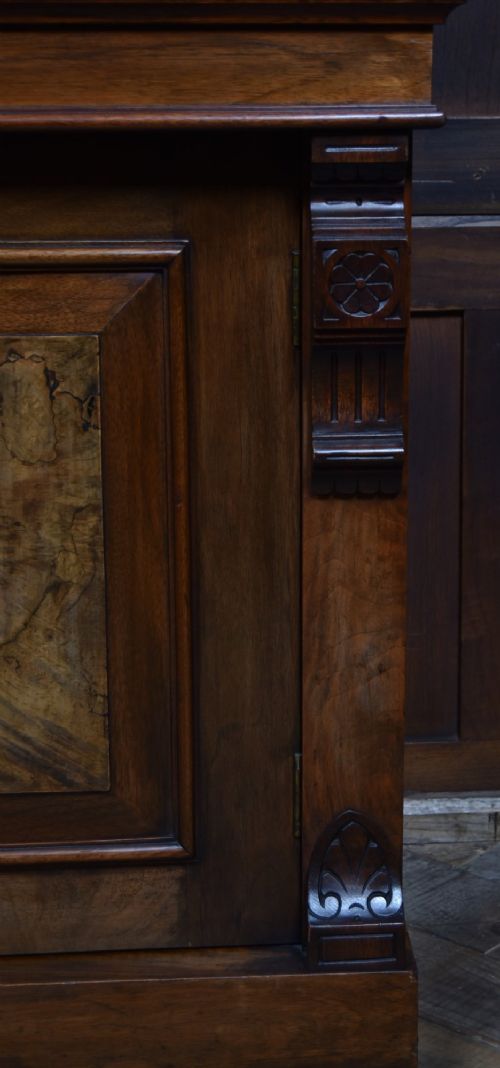 An Edwardian walnut glazed bookcase featuring a two-door upper section with glass panels, adjustable interior shelving, and a lower cabinet with burr walnut door panels. View X