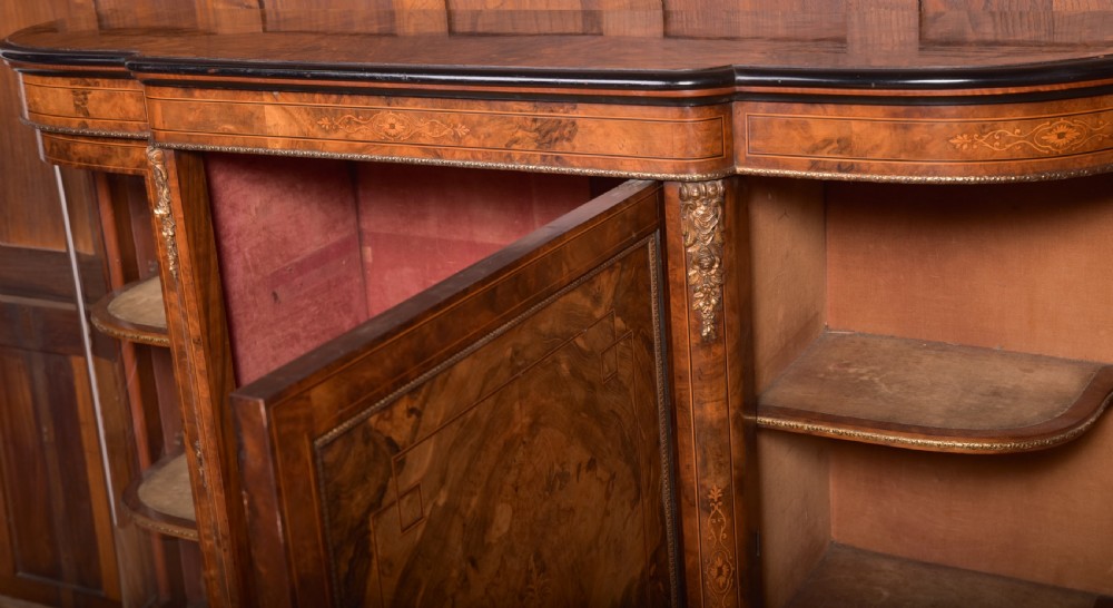A Victorian burr walnut credenza featuring a central inlaid cupboard door flanked by curved glass display sections with gilt-bronze mounts. View IX